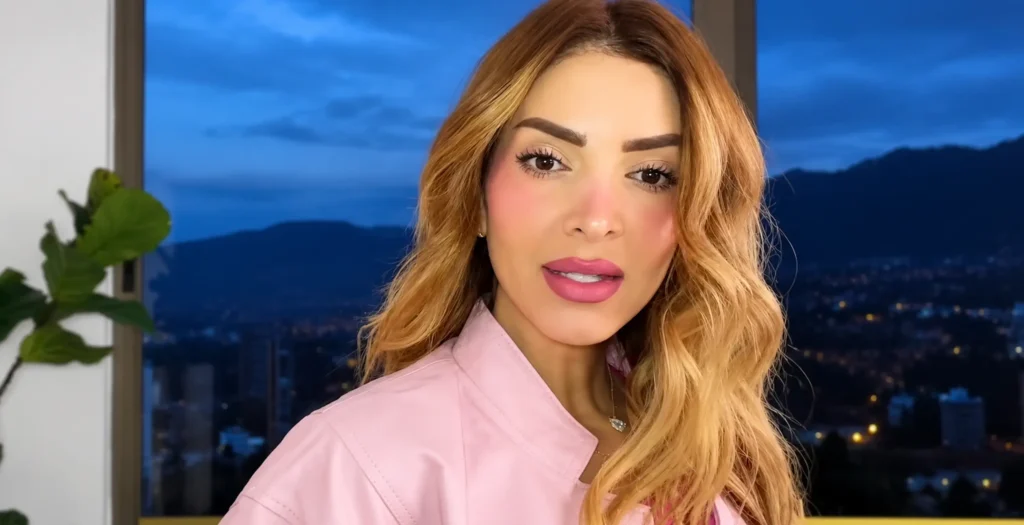 Dani Duke, influenciadora y empresaria colombiana, con cabello rubio ondulado y chaqueta rosada.