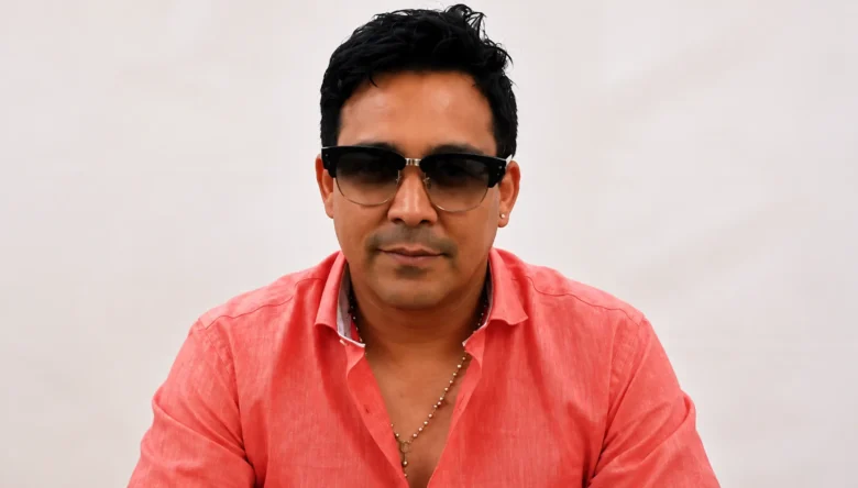 Donny Caballero, cantante colombiano e integrante de Dragón y Caballero, con camisa rosada y gafas oscuras.