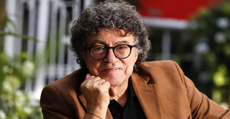 Piero, cantautor de “Mi viejo”, con gafas negras y chaqueta marrón.