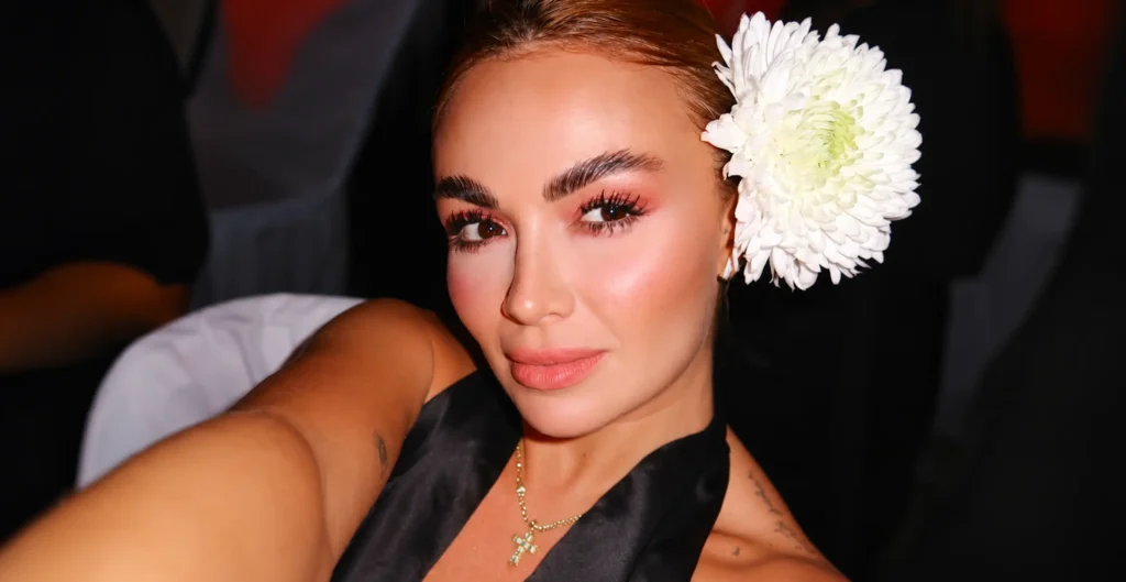 Sara Uribe, modelo y presentadora colombiana, con vestido negro y una flor blanca en el cabello.
